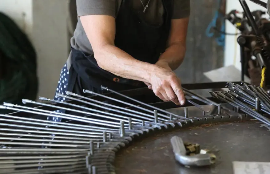 Frédérique Fert place les aiguilles sur une machine à tisser dans l'atelier de Nyons.